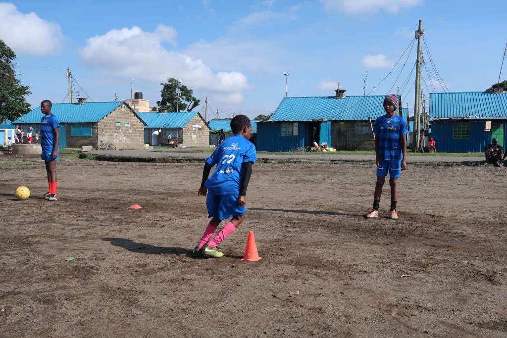 Boys wearing SuperInvite t-shirt playing football in Kenya