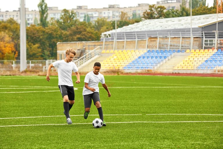 Boys playing football at stadium