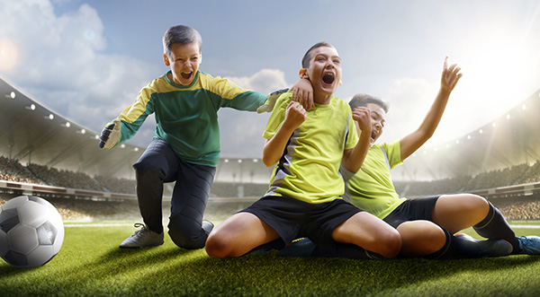 Three happy boys on the football field