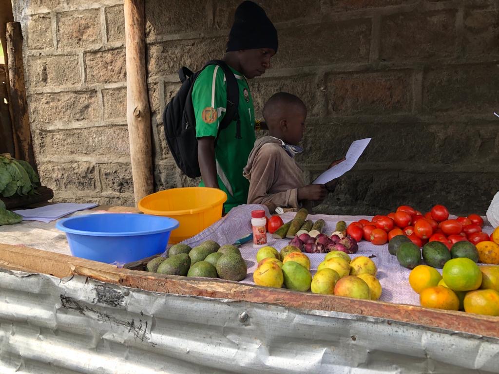 Boys at the market in Kenya, reading some letter