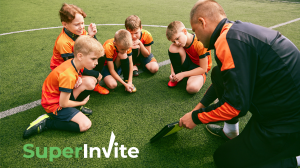 Coach and kids discussing game strategy on the field