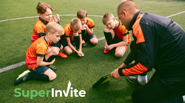 Entrenador y niños discutiendo estrategia de juego en el campo