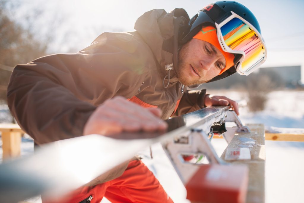 Male skier checks skis before skiing