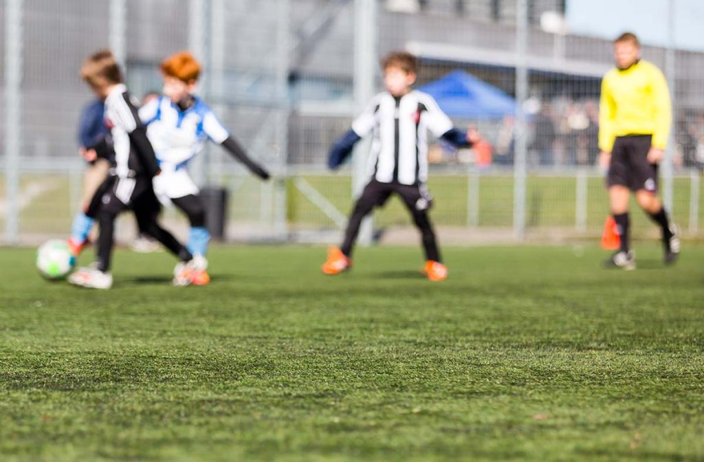 Niños jugando al fútbol en el campo.